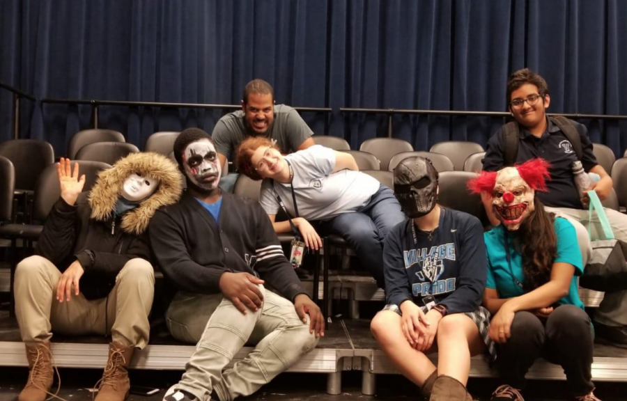 Haunted house attendees posing for a photo with their costumes in the Black Box Theatre.
