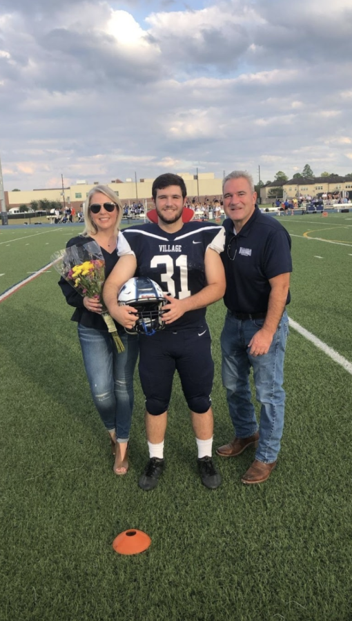 Village football captain Marshall De Benedictis (senior) posing with parents at the football game.