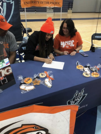 Pictured is Sydney Ward (12) signing and committing to her college. 