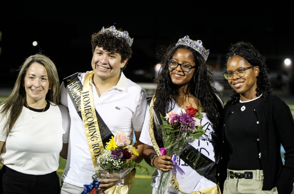 A YEAR OF WINS: From left to right, winner of Homecoming King, Anthony Rodas(12) and his mother, stand beside Homecoming Queen, Mari Felipe(12), and her mother as they all share a celebratory hug afterwards.