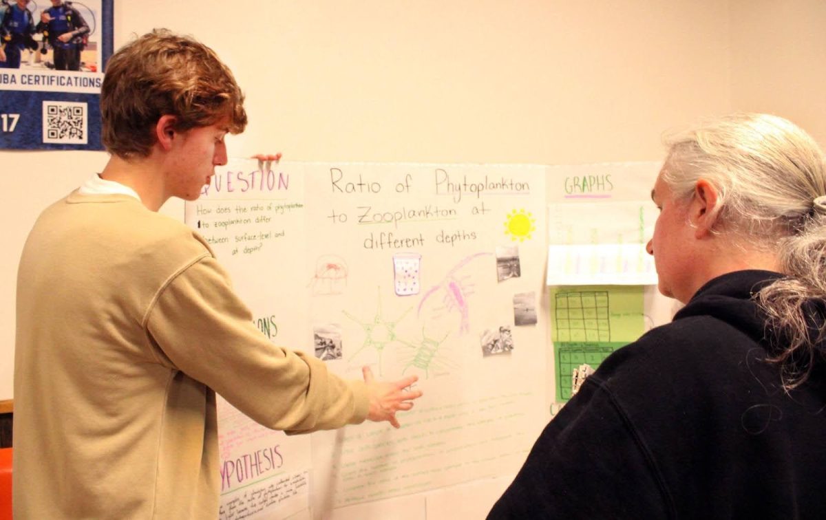 Presenting research, Samuel Swam (11) explains his group's research project to Kerri Peters (VHS Staff).